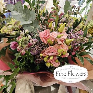 Handtied in water, including lilac, lisianthus, snaps, blooms, Santini, statice, and mixed foliages.