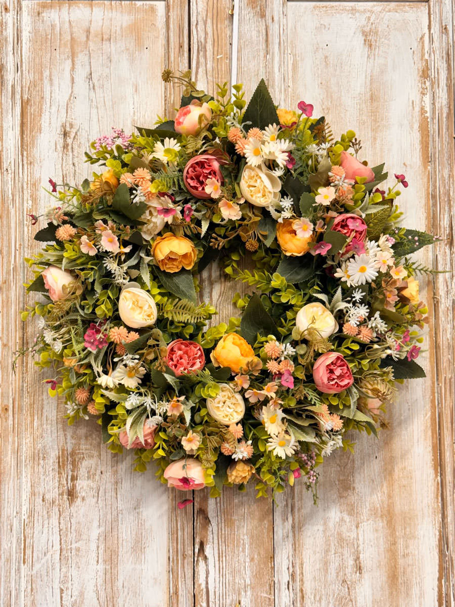 Peaches and Cream wreath featuring Ranunculus, Roses, Daisy’s, Thistle, Blossom, Mixed foliages including ferns and Eucalyptus.