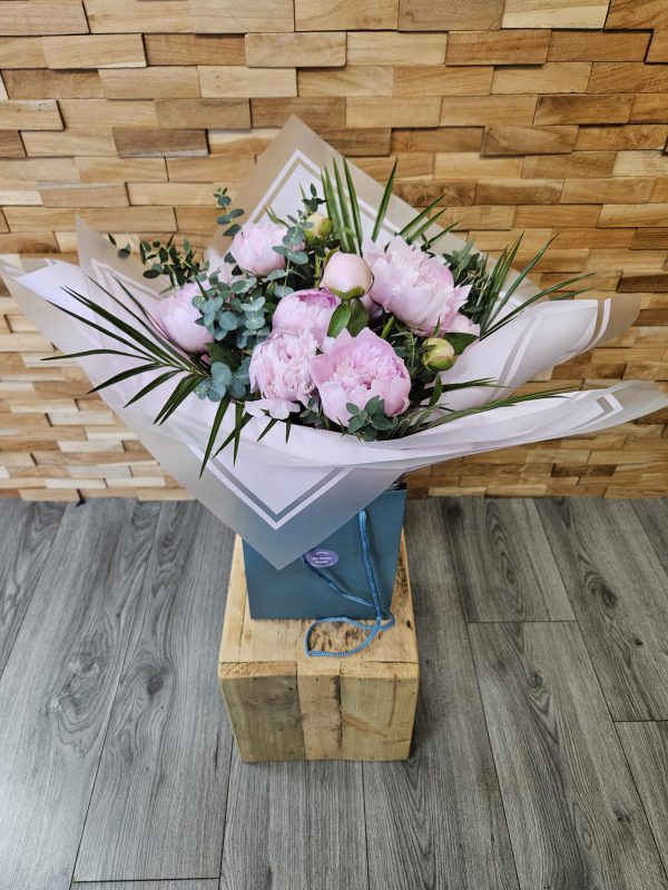 A stunning bouquet of 10 seasonal pink peonies, hand-tied and delivered in water. Classic, elegant, and perfect for any occasion.