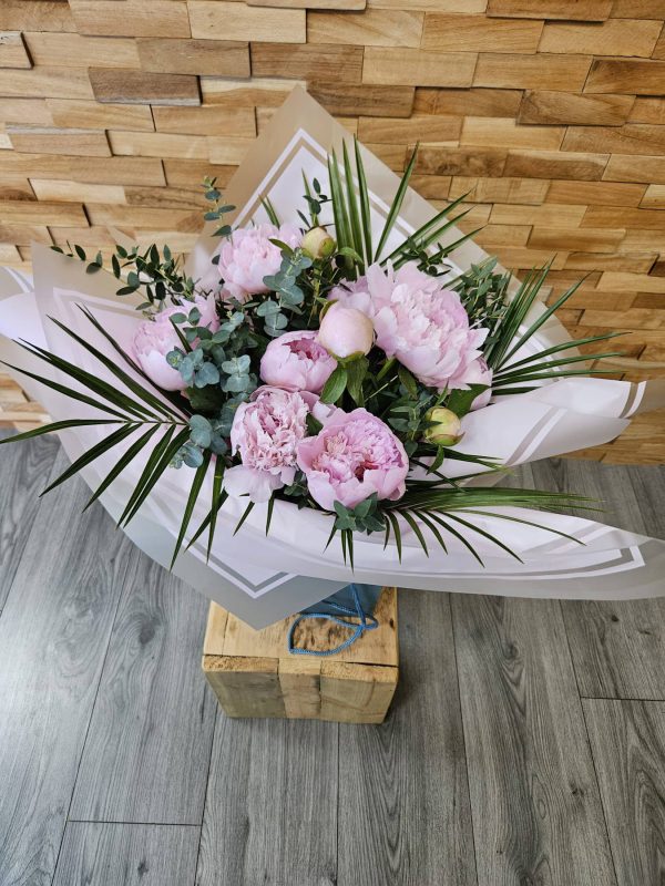 A stunning bouquet of 10 seasonal pink peonies, hand-tied and delivered in water. Classic, elegant, and perfect for any occasion.